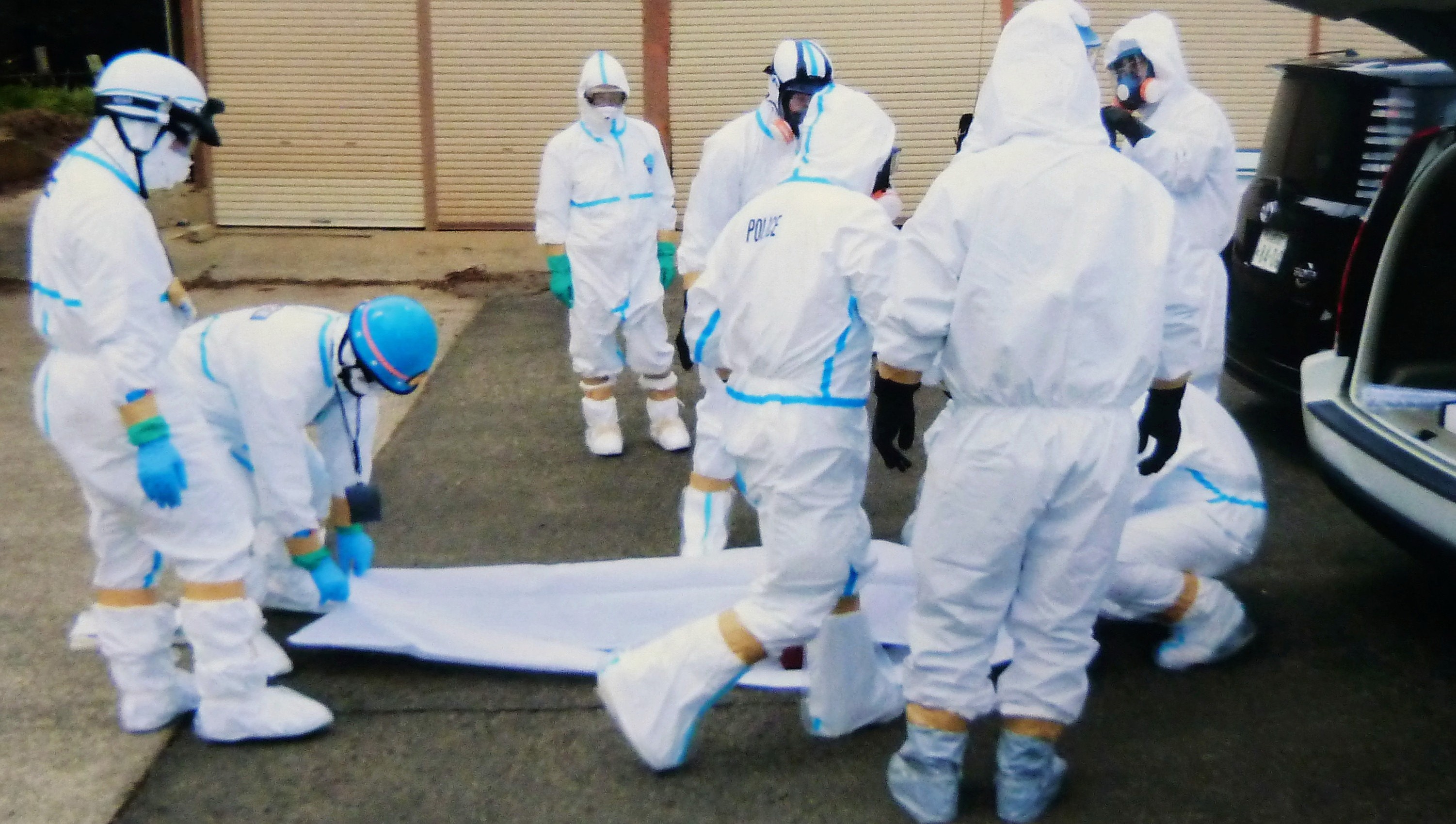 Záchranári pri Fukušime nakladajú mŕtve telo